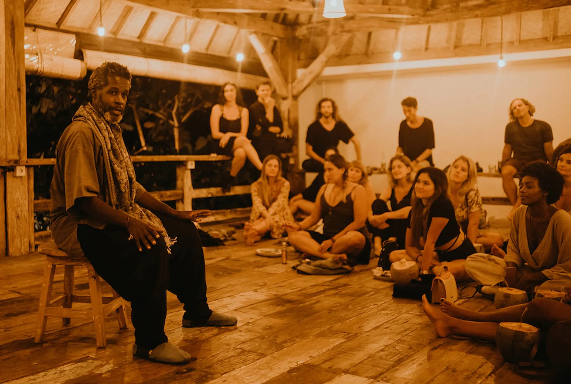 A speaker sharing from a stool at Unplugged